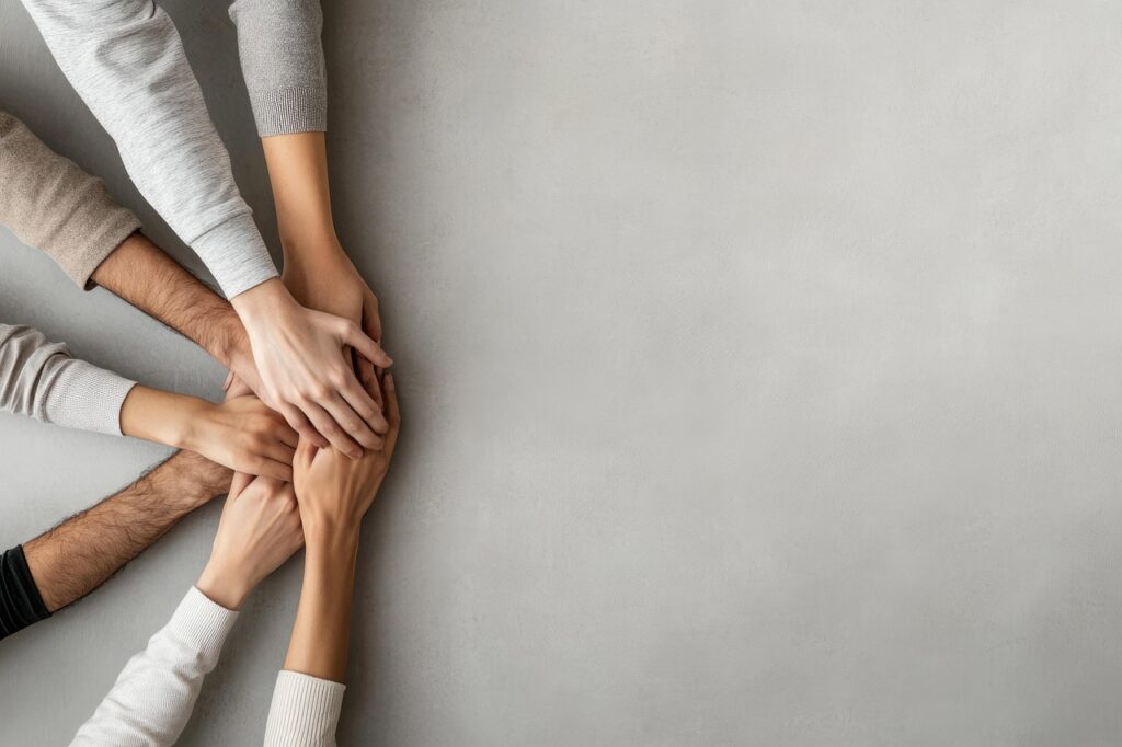 Várias mãos se unindo em um gesto de colaboração e união, simbolizando trabalho em equipe e cooperação entre pessoas.